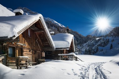 Winter ski chalet and cabin in snow mountain landscape