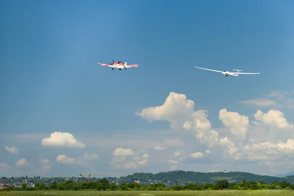 Un avion à moteur rouge remorque un planeur dans les airs — Photo