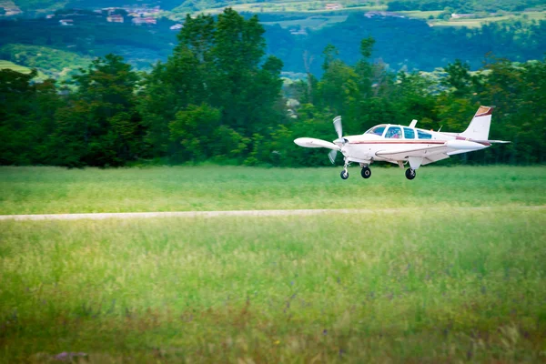 Small sport prop aircraft landing on aspahlt runway — Stock Photo, Image