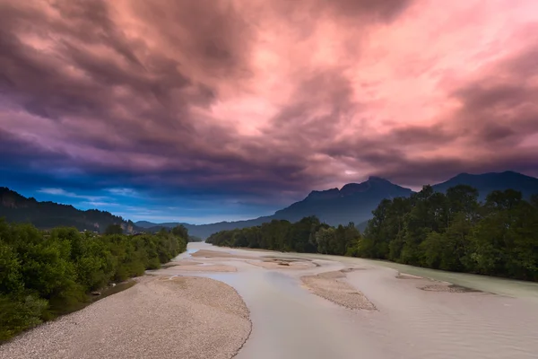 Cielo rojo surrealista antes de la tormenta en el río en el bosque verde — Foto de Stock