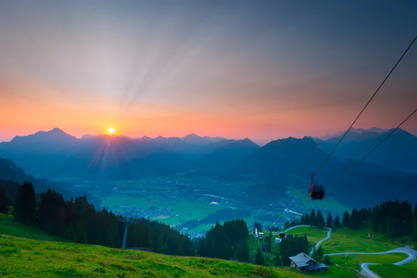 Solstrålar medan sunrise i österrikiska bergen med ropewayen — Stockfoto