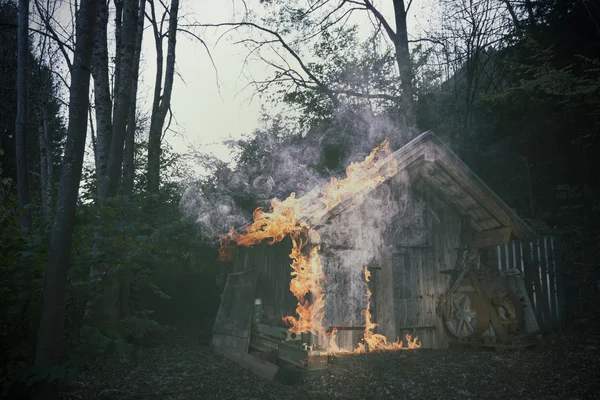 Alte brennende Holzhütte steht am Wald — Stockfoto