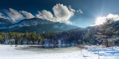Güneş Bulutların arasından parlıyor ile Avusturya Alplerinde içinde küçük donmuş göl