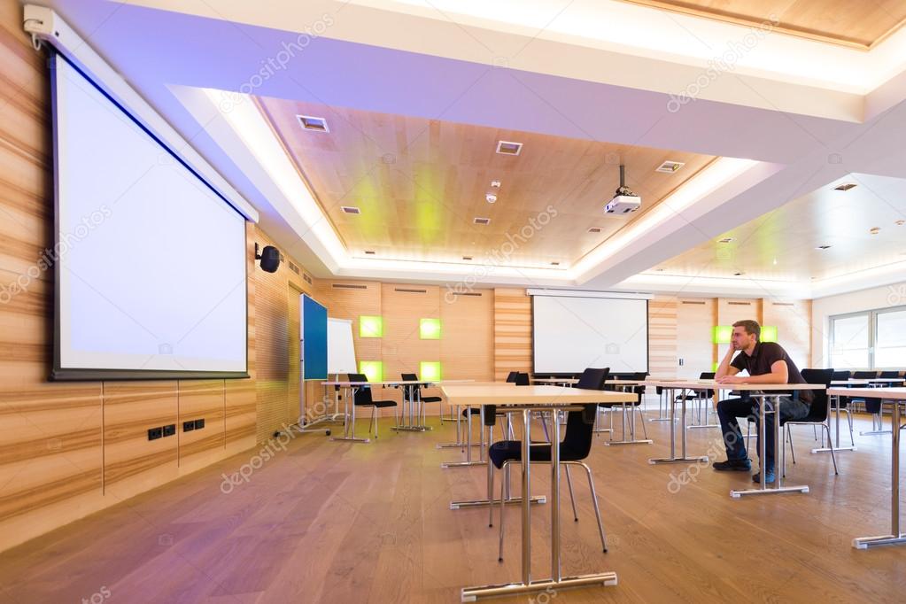 Desperated man in conference room with white projection screen