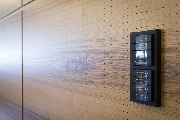 Tombol hitam untuk kontrol lampu pada dinding akustik kayu — Stok Foto