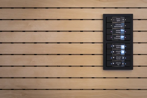 Black switches for light control on wooden acoustic wall — Stock Photo, Image