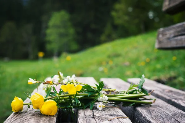 Romantische stelletje gele bloemen op oude houten hout Bank — Stockfoto