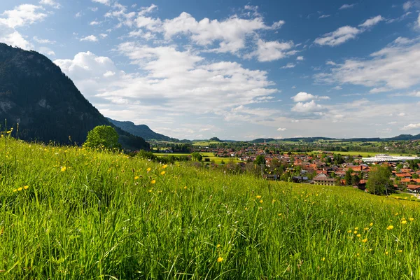 Lovely village in bavaria with view over fresh green meadow at spring — Stock Photo, Image