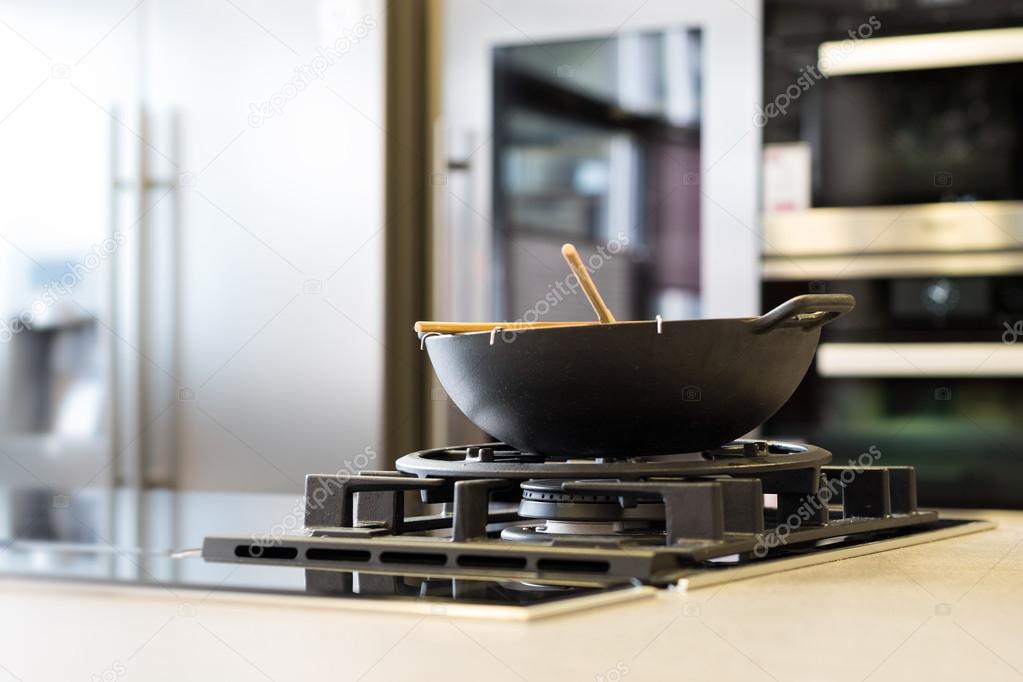 Noodle wok on gas stove on workplate in modern kitchen