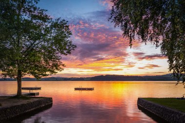 Moody gün batımında göl wallersee Avusturya ağaç ve ahşap platform