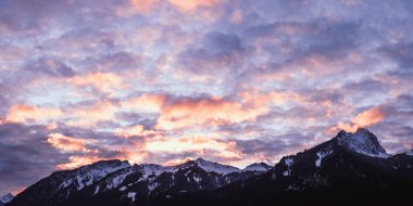 Sonbaharda Tyrol 'daki karlı hahnenkamm dağ sırası üzerinde harika bir bulut oyunu.