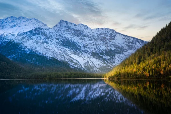 美丽宁静的普朗西湖 背景是阳光普照的绿色秋天森林和白雪覆盖的高山 — 图库照片