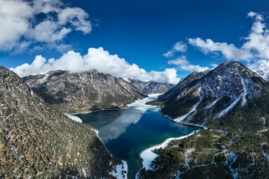 Soğuk mavi göl planörleri güneşli bir günde Tyrol Alp dağlarında kışın
