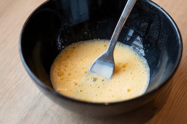 Köpüklü yumurta sarıları ve siyah bir kasede süt jölesi Paskalya örgü örer gibi hamur işleri yaymak için.