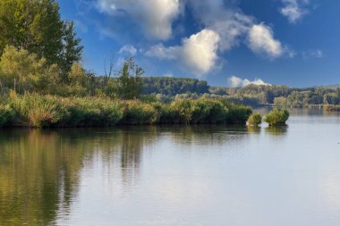 Şimdi Mlyny rezervuarı ve arka planda Çek Cumhuriyeti 'ndeki İlahi Hrady harabeleriyle dolu St. Linhart ve Palava kilisesi var..
