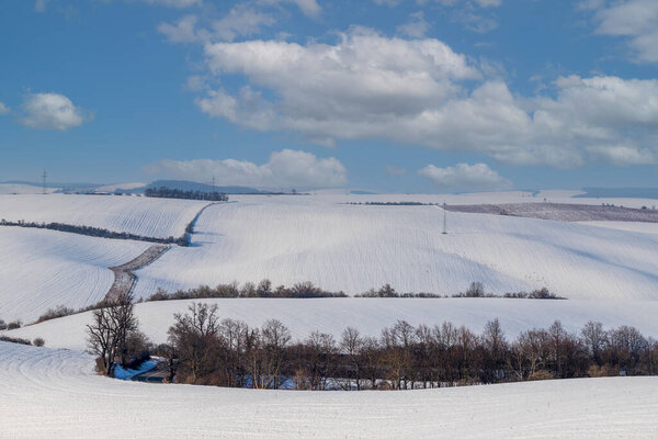 Зимний снежный пейзаж в Чехии - в Европе. Голубое небо с белыми облаками.