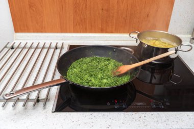 Yeşil ıspanak seramik bir tavada pişirilir..