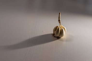 Masanın üzerine sarımsaklı bir tokmak güzel gölgeler oluşturur..