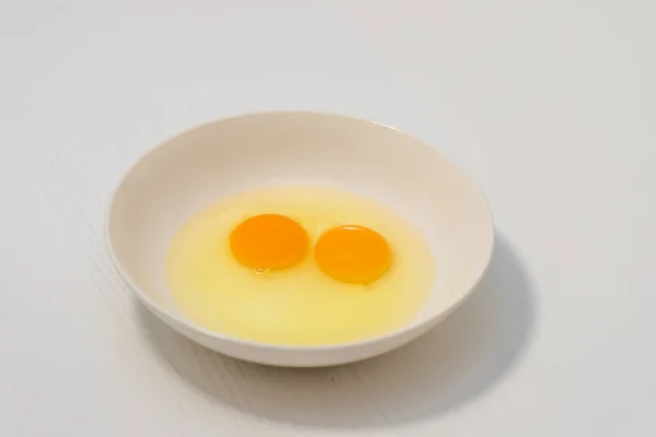 Два Сырых Куриных Яйца Белой Тарелке Два Сырых Яичных Желтка — стоковое фото