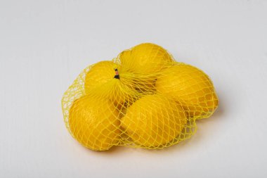 Turunçgil meyvesi. Beyaz bir masada satılık limonlar.