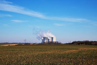 Çek Cumhuriyeti, Avrupa 'daki Dukovany Nükleer Santrali. Duman soğutma kuleleri. Gökyüzünde bulutlar var. Arka planda İskoçya 'nın doğası....