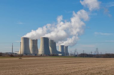 Çek Cumhuriyeti, Avrupa 'daki Dukovany Nükleer Santrali. Duman soğutma kuleleri. Gökyüzünde bulutlar var. Arka planda İskoçya 'nın doğası....