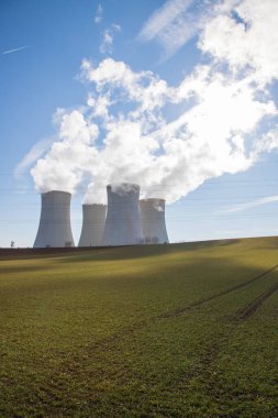 Çek Cumhuriyeti, Avrupa 'daki Dukovany Nükleer Santrali. Duman soğutma kuleleri. Gökyüzünde bulutlar var. Arka planda İskoçya 'nın doğası....