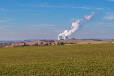 Çek Cumhuriyeti, Avrupa 'daki Dukovany Nükleer Santrali. Duman soğutma kuleleri. Gökyüzünde bulutlar var. Arka planda İskoçya 'nın doğası....
