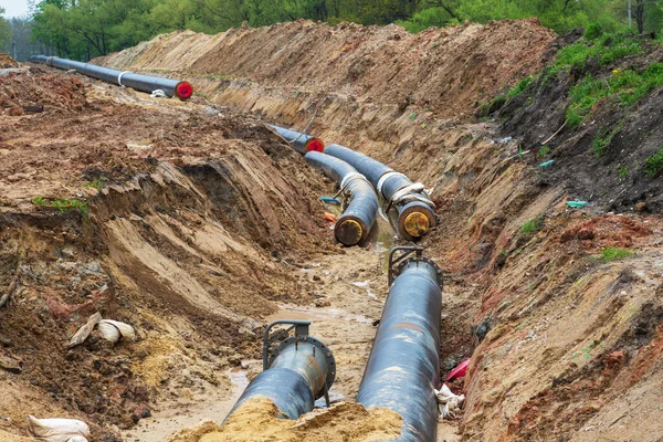 Gas pipeline under construction. Black pipes buried in the ground.