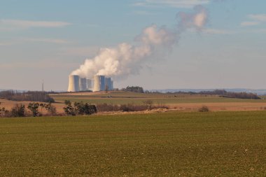 Çek Cumhuriyeti, Avrupa 'daki Dukovany Nükleer Santrali. Duman soğutma kuleleri. Gökyüzünde bulutlar var. Arka planda İskoçya 'nın doğası....