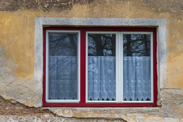 A new window in an old house. There is old plaster around the window.