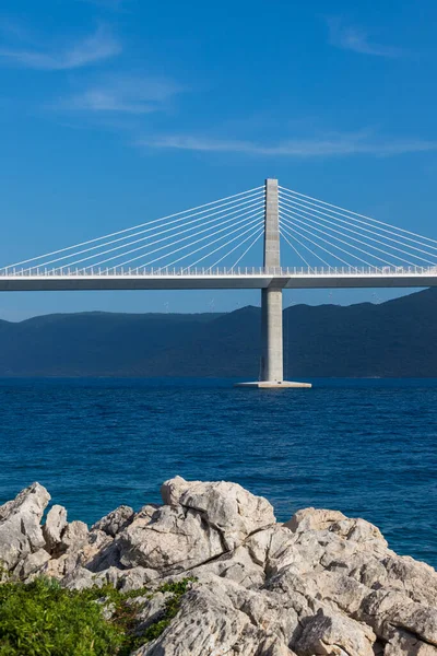 Beautiful modern bridge over the sea to the island of Peljesac in Croatia - Europe. Against the background of mountain ranges and a nice sky with clouds.