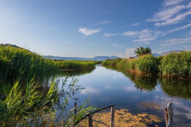Hırvat manzarası. Hırvatistan 'ın Tustevac bölgesindeki sulama kanalları. Arka planda dağlar ve mavi gökyüzü var..