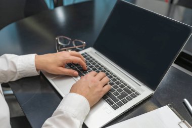 Ofiste bilgisayarla çalışan bir kadın. Eller klavyede.