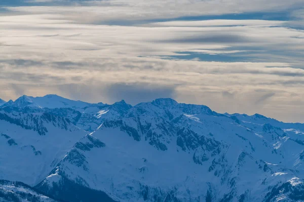雪のビュー Zell AmのSchmittenスキー場で山のキャップを参照してください 背景には雲が立ち並ぶ美しい空 — ストック写真