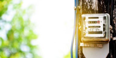 Yol kenarındaki çimento direğine asılan saat göstergesi Asya 'daki her evde elektrik kullanımını izlemek ve ölçmek için..