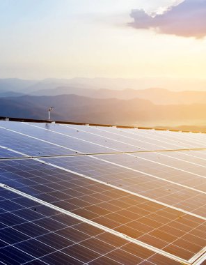 Solar panels on the roof which are dirty with dust, has bird droppings and rust stains on the surface, sunlight and blurred mountain background, soft and selective focus.