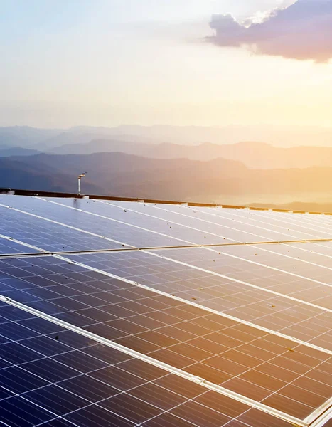 Solar panels on the roof which are dirty with dust, has bird droppings and rust stains on the surface, sunlight and blurred mountain background, soft and selective focus.