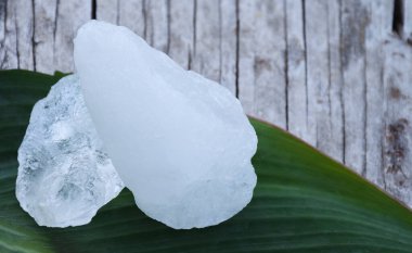 Yaprak arkaplanındaki alüminyum küpleri, bitki, vücut bakımı, cilt bakımı, su temizleme ve koltuk altı kokusunu koruma konsepti.