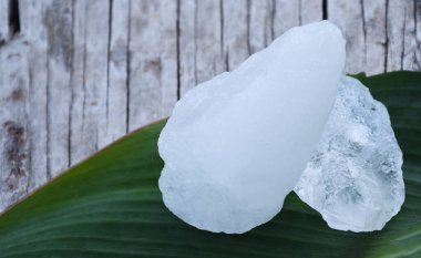 Yaprak arkaplanındaki alüminyum küpleri, bitki, vücut bakımı, cilt bakımı, su temizleme ve koltuk altı kokusunu koruma konsepti.