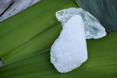 Yaprak arkaplanındaki alüminyum küpleri, bitki, vücut bakımı, cilt bakımı, su temizleme ve koltuk altı kokusunu koruma konsepti.