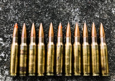 Beton zeminde, geçmişi bulanık eski tüfek mermileri. Yumuşak ve seçici odaklanma. Klasik mermi koleksiyonu kavramı.