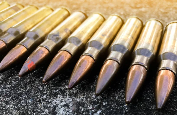 Beton zeminde, geçmişi bulanık eski tüfek mermileri. Yumuşak ve seçici odaklanma. Klasik mermi koleksiyonu kavramı.