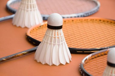 Beyaz badminton topu ve raketi kapalı badminton kortunda, kopyalama alanı, mekik horozlarına yumuşak ve seçici odaklanma.