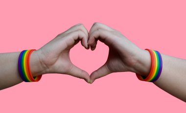 Igbt, eşcinsel aşk ve homoseksüel ilişkiler konsepti - gay gururlu erkek ellerine yakın gökkuşağı farkındalığı bileklikleri kalp hareketlerini kesme yollarıyla gösteren bileklikler
