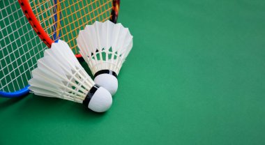 Beyaz badminton mekikleri ve raketleri kapalı badminton kortunda yeşil katta, kopyalama alanı, dayanıklılık egzersizi konsepti kapalı badminton sporu.