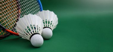 Beyaz badminton mekikleri ve raketleri kapalı badminton kortunda yeşil katta, kopyalama alanı, dayanıklılık egzersizi konsepti kapalı badminton sporu.