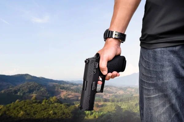 9mm automatic pistol holding in right hand of shooter, concept for security, robbery, gangster, bodyguard around the world. selective focus on pistol.