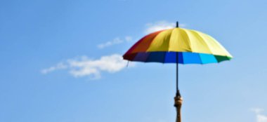 Çok renkli şemsiye ve mavimsi görüntünün bulanık arkaplanı.