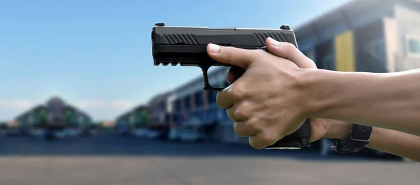 9mm automatic pistol holding in hands of shooter, concept for security, robbery, gangster, bodyguard around the world. selective focus on pistol.